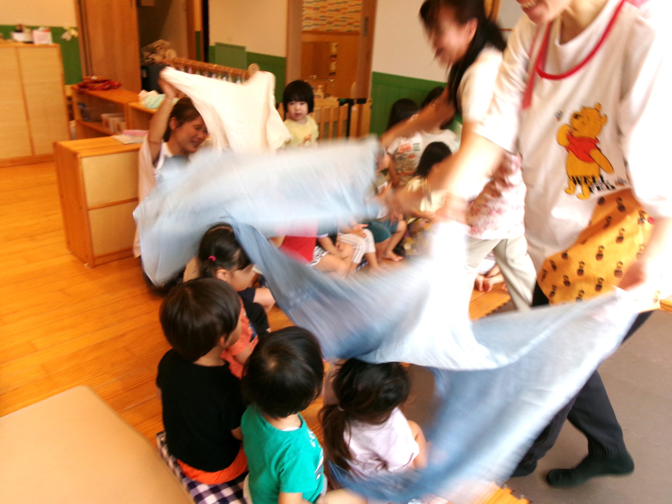 わらべ歌遊びをしました！♪おおなみ〜、こなみ〜、か〜ぜがふいたら、まわりましょ〜♪布をもって左右に腕を振ることは2歳の子たちにとっては、とても難しいこと。楽しく遊びながら成長します！